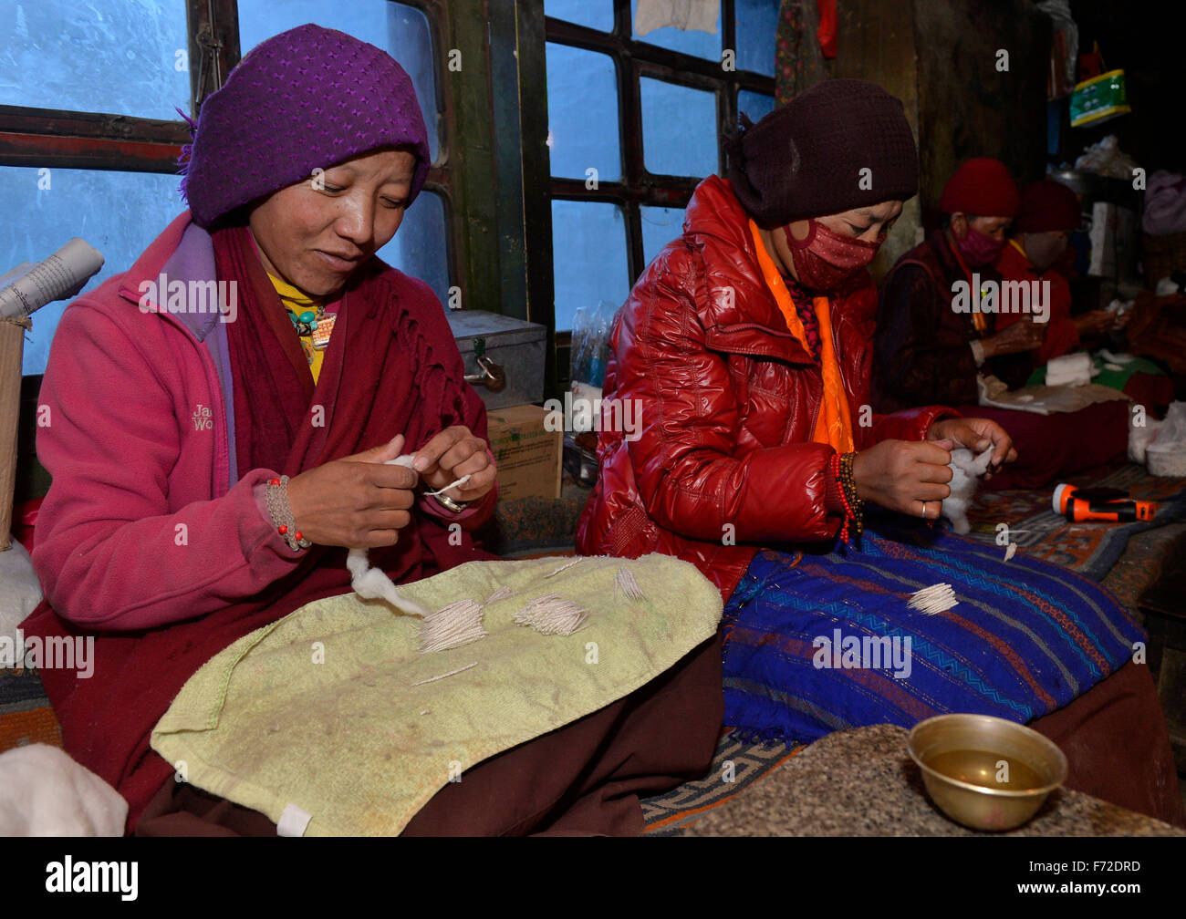 Tingri, China's Tibet Autonomous Region. 20th Nov, 2015. Nuns make wicks to offer to the Buddha at the Rongpu Monastery, the world's highest monastery at the altitude of over 5,000 meters, at the foot of Mount Qomolangma, or Mount Everest, in Tingri County, southwest China's Tibet Autonomous Region, Nov. 20, 2015. © Liu Dongjun/Xinhua/Alamy Live News Stock Photo