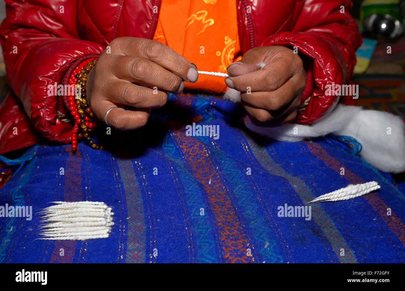 Tingri. 20th Nov, 2015. Photo taken on Nov. 20, 2015 shows a nun making wicks to offer to the Buddha at Rongpu Monastery, the world's highest monastery at the altitude of over 5,000 meters, at the foot of Mount Qomolangma, or Mount Everest, in Tingri County, southwest China's Tibet Autonomous Region. © Liu Dongjun/Xinhua/Alamy Live News Stock Photo