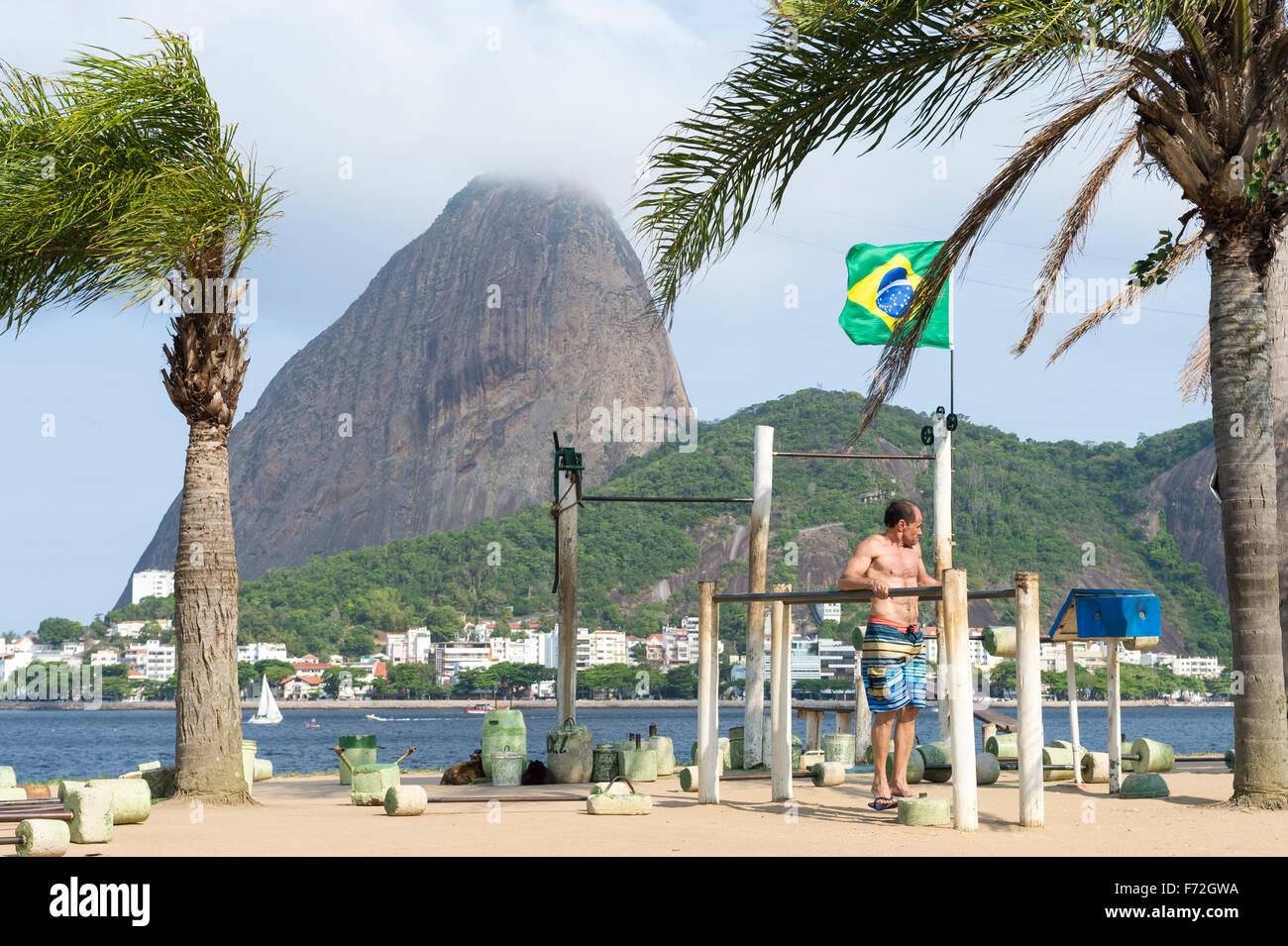 RIO DE JANEIRO, BRAZIL - OCTOBER 17, 2015: Brazilian man exercises at an outdoor workout station in the Flamengo neighborhood. Stock Photo