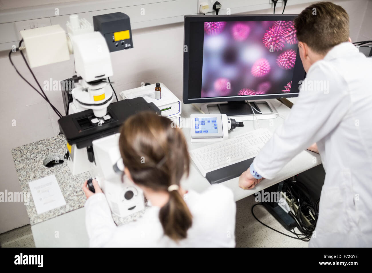 Scientist looking through a microscope Stock Photo