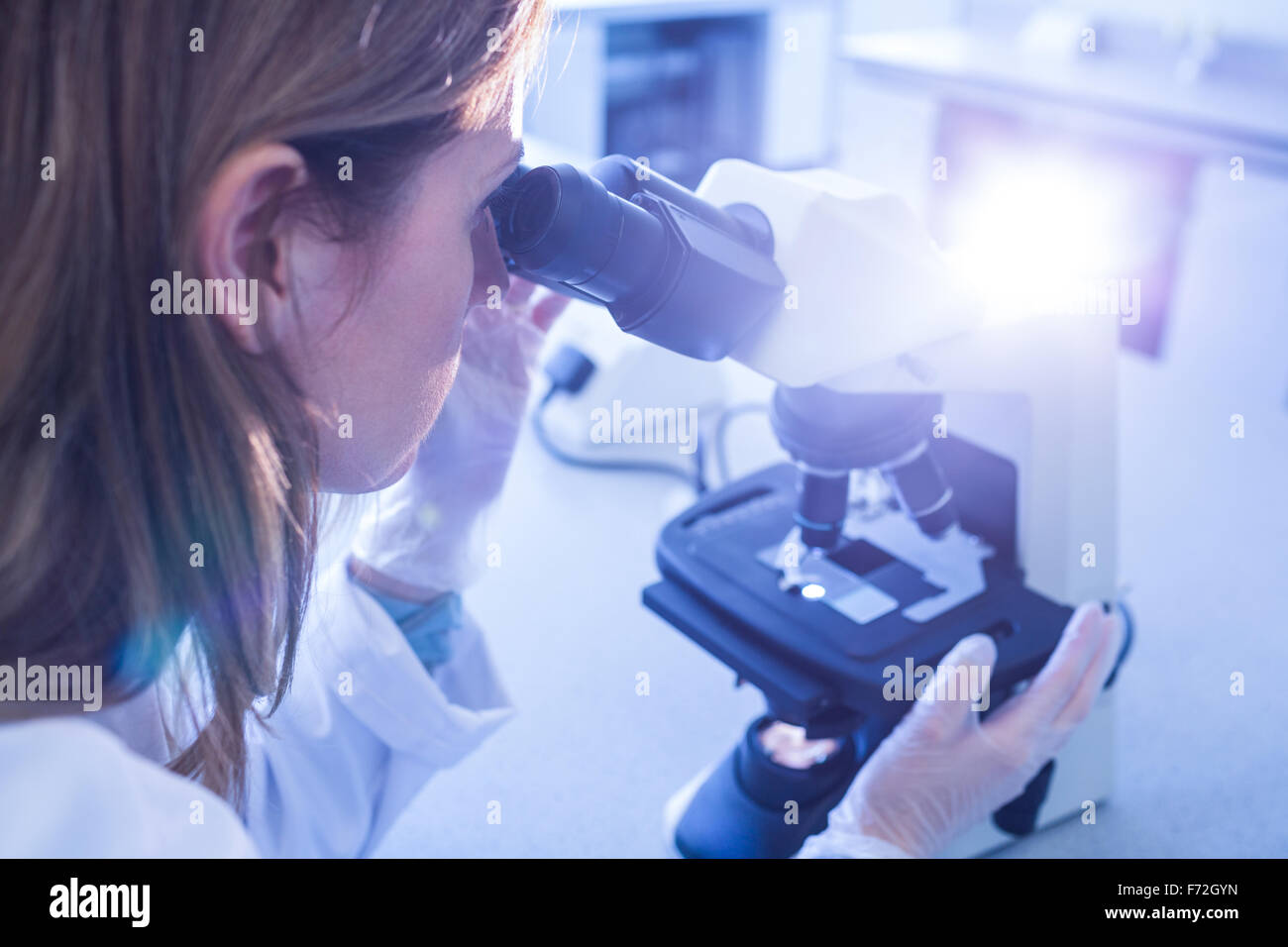 Scientist working with a microscope in laboratory Stock Photo