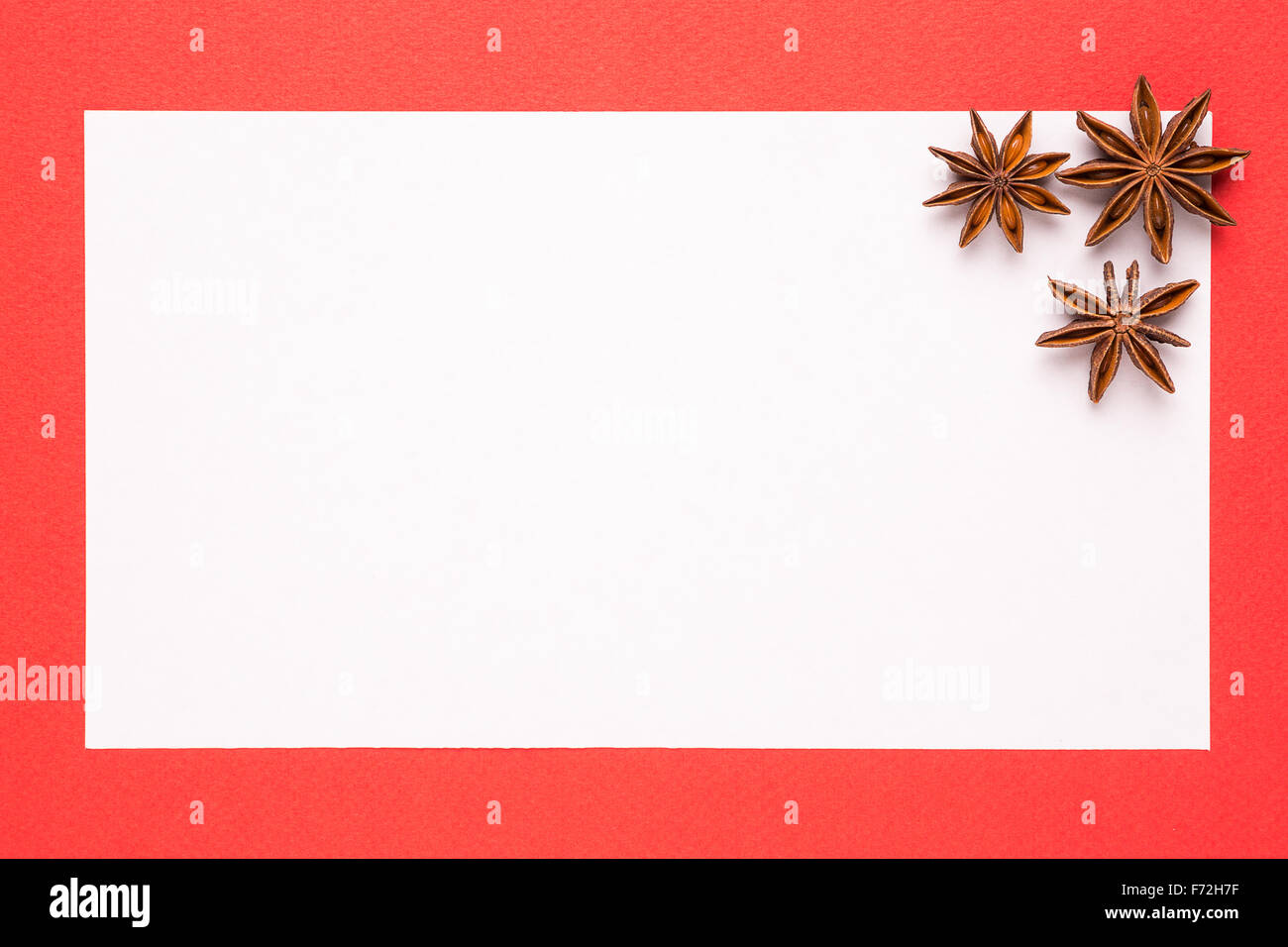 blank christmas card with anise star on red background Stock Photo