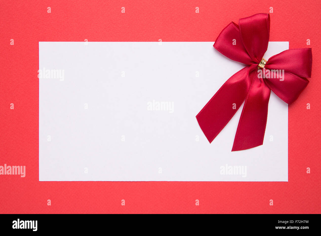 Blank Christmas card or invitation with bow on red background Stock Photo