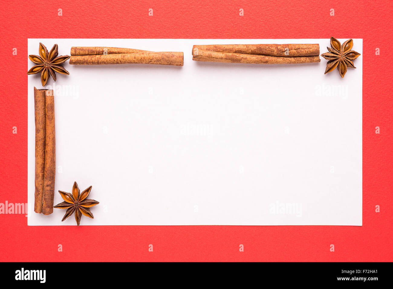 blank Christmas card with anise star and cinnamon on red background Stock Photo