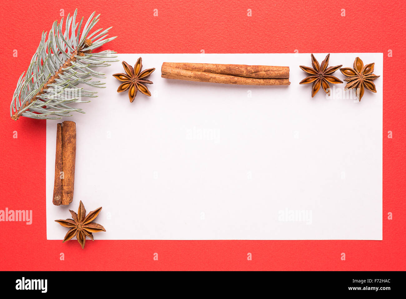 blank Christmas card with anise star and cinnamon on red background Stock Photo