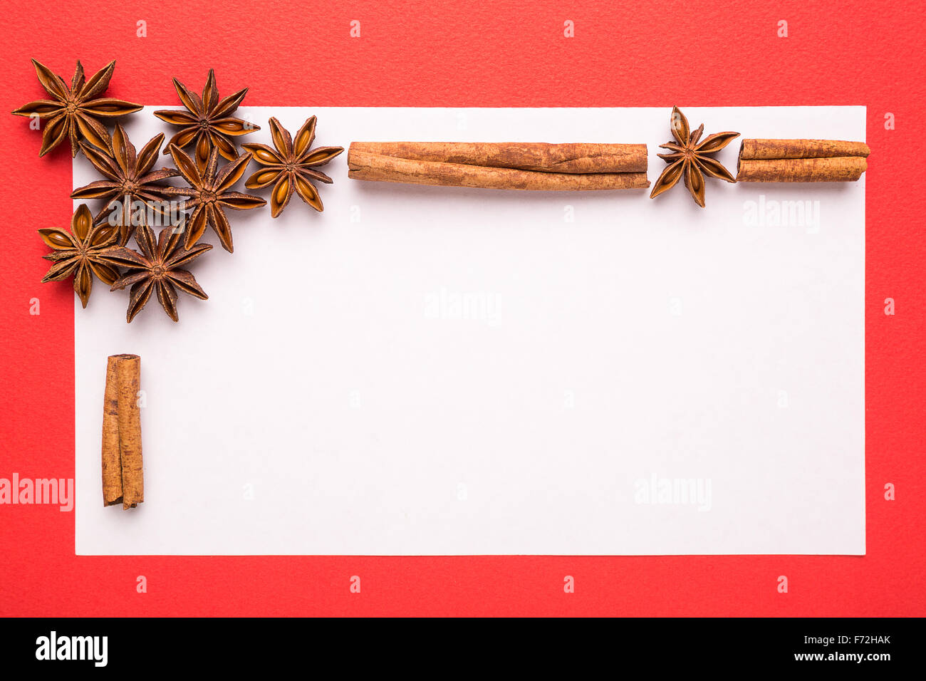 blank christmas card with anise star and cinnamon on red background Stock Photo