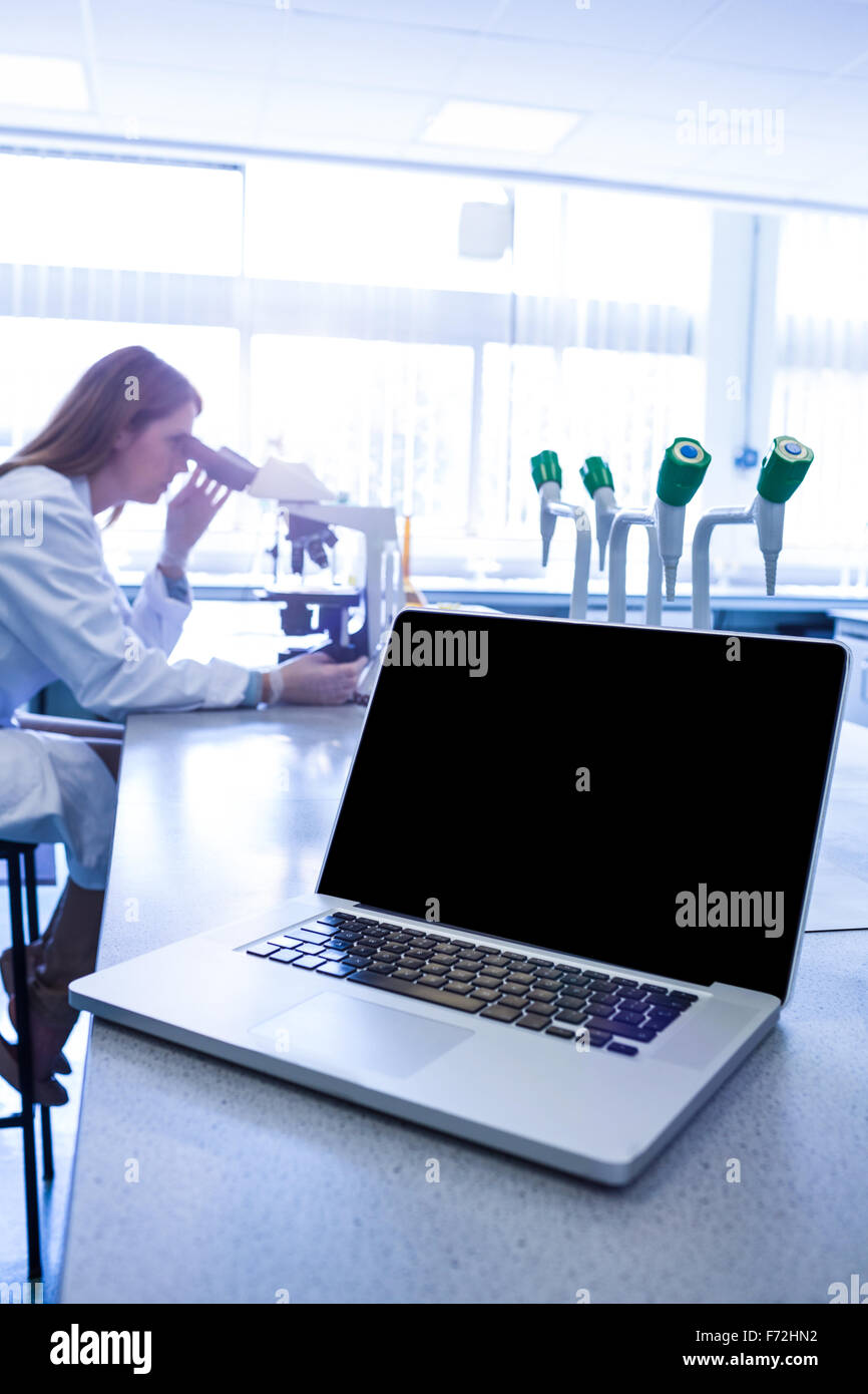 Scientist working with a microscope in laboratory Stock Photo