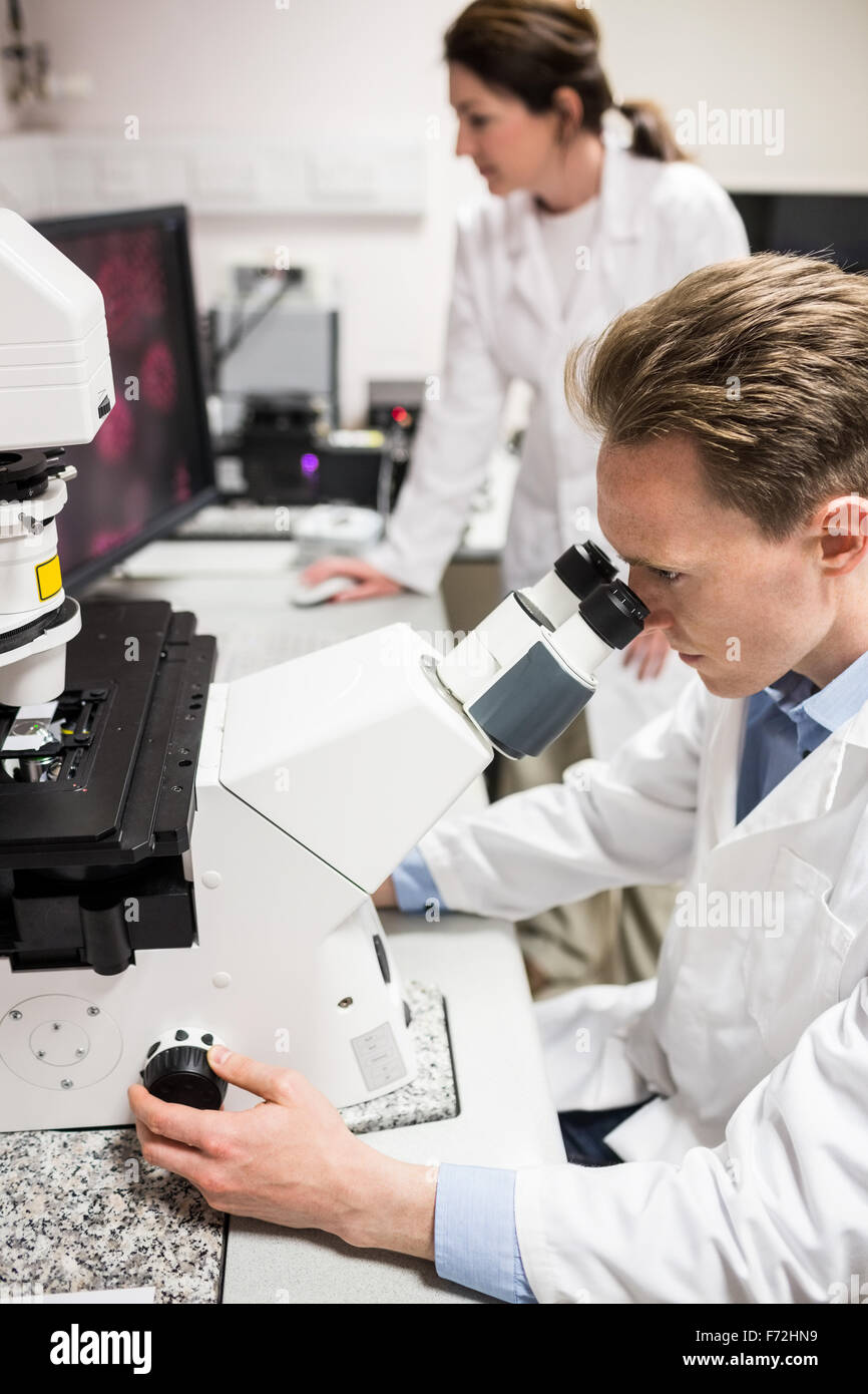 Scientist looking through a microscope Stock Photo