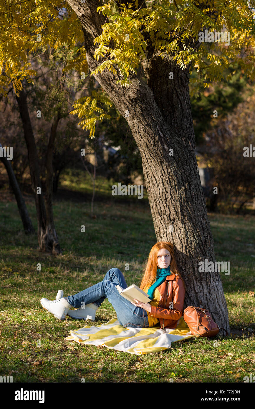 Girl reading a book sitting under a tree hi-res stock photography and ...