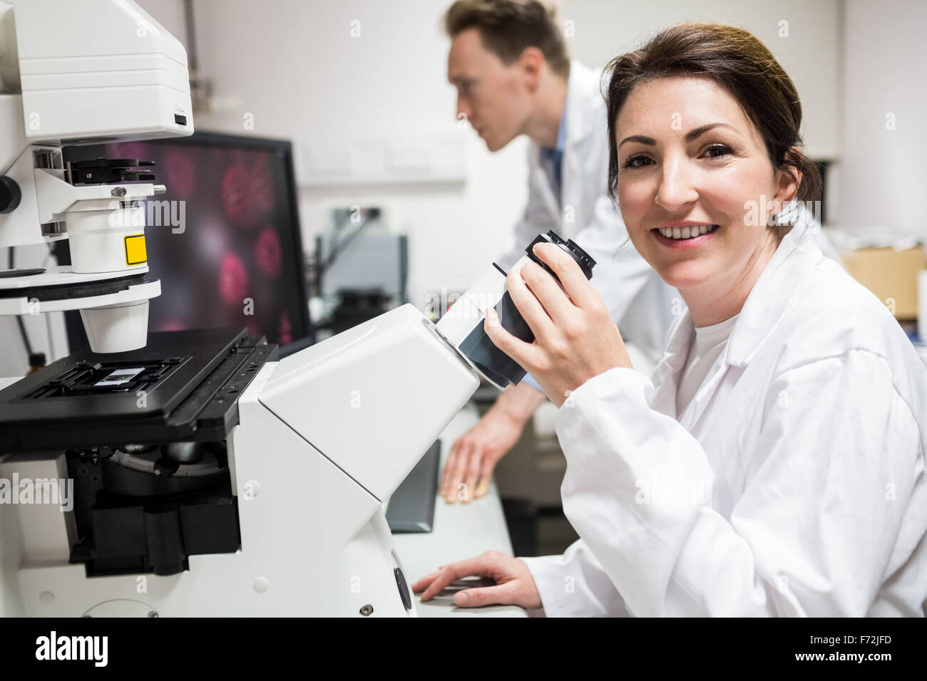 Scientist looking through a microscope Stock Photo