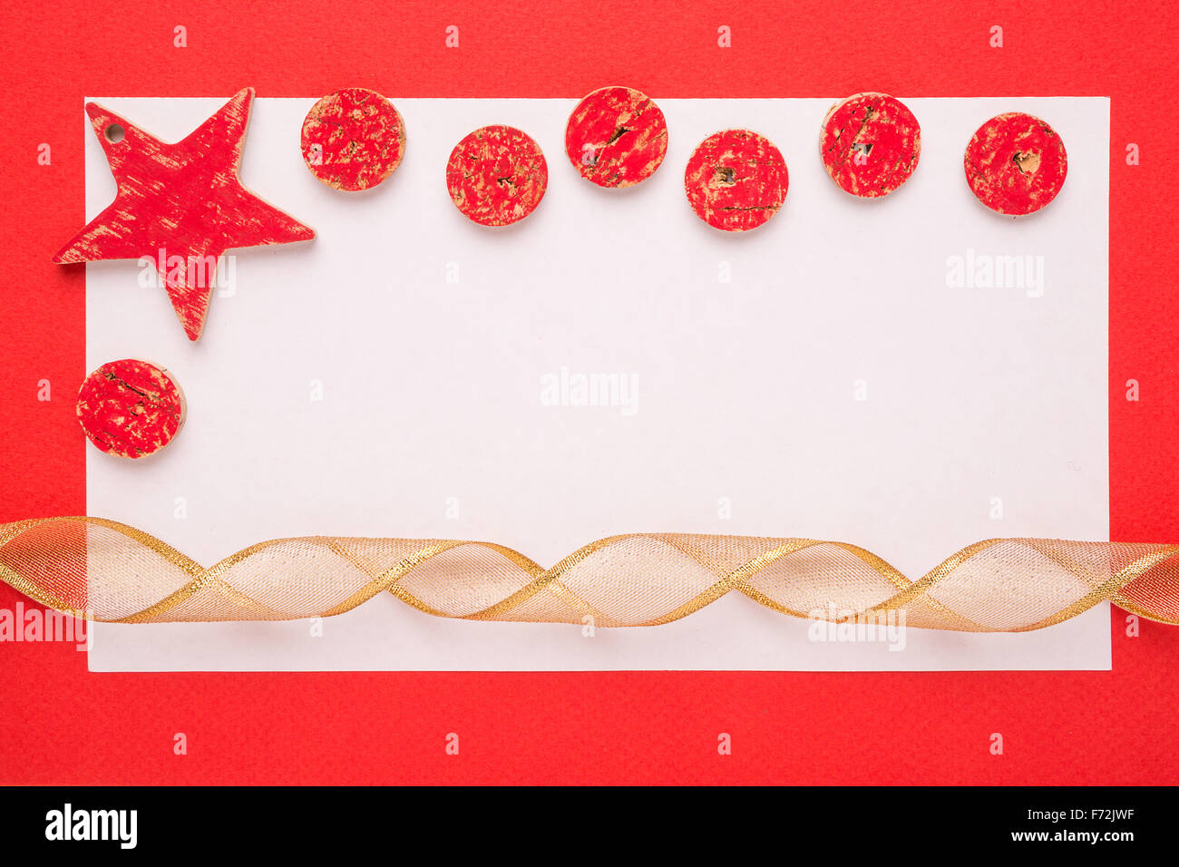 Blank Christmas card or invitation with christmas decoration and ribbon on red background Stock Photo
