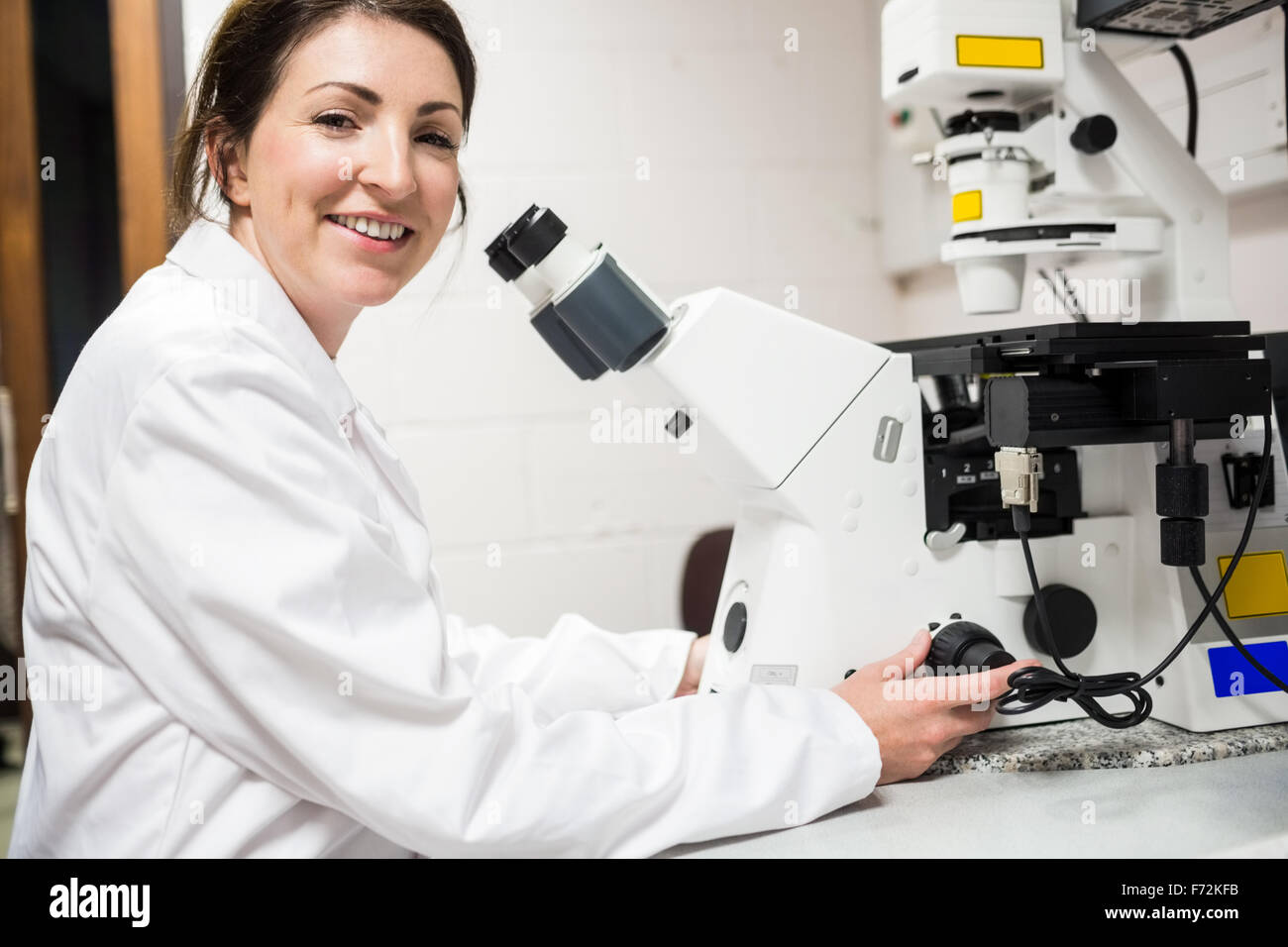 Scientist looking through a microscope Stock Photo