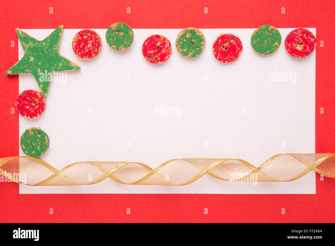 Blank Christmas card or invitation with christmas decoration and ribbon on red background Stock Photo