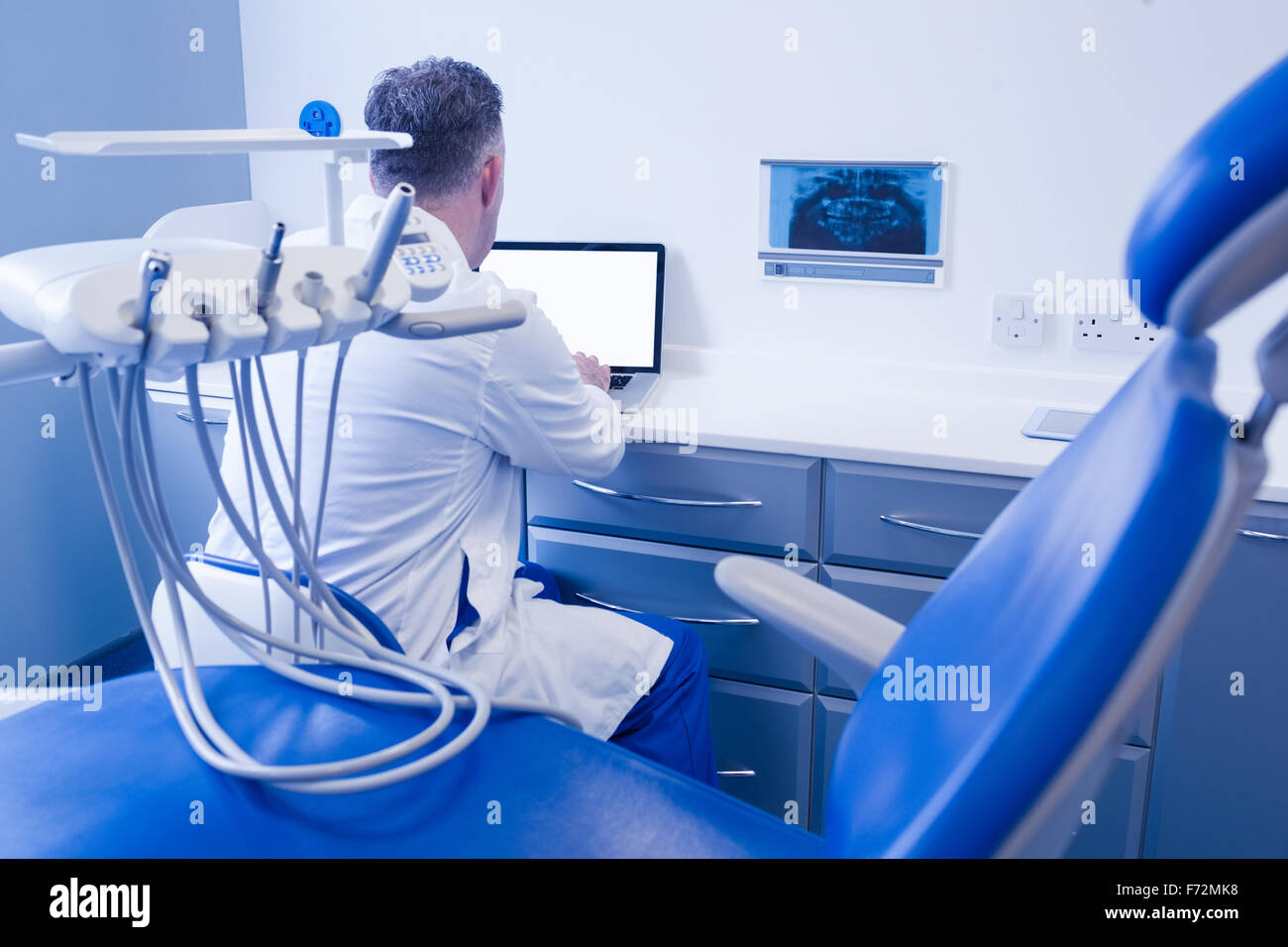 Dentist sitting and using computer Stock Photo Alamy