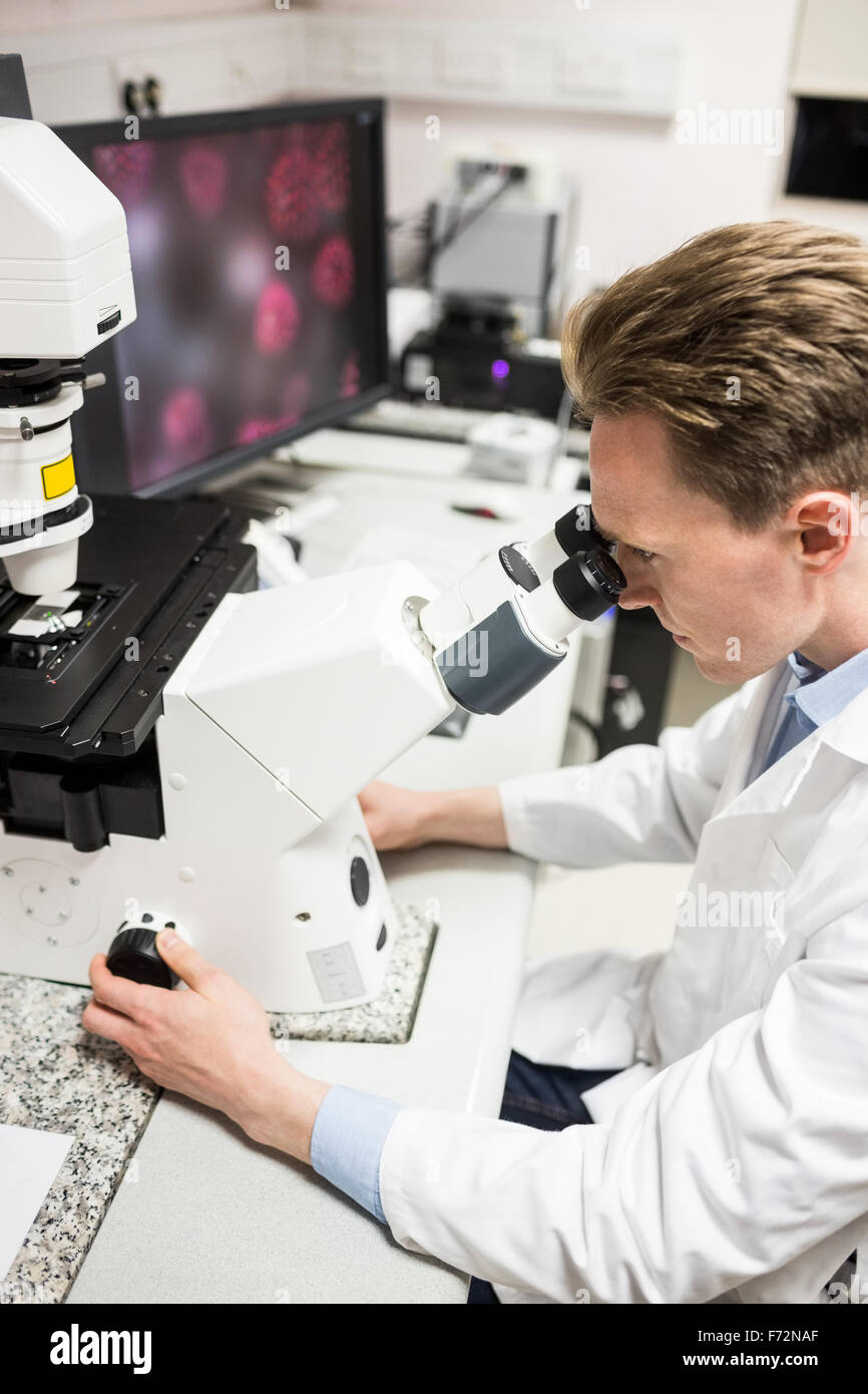 Scientist looking through a microscope Stock Photo