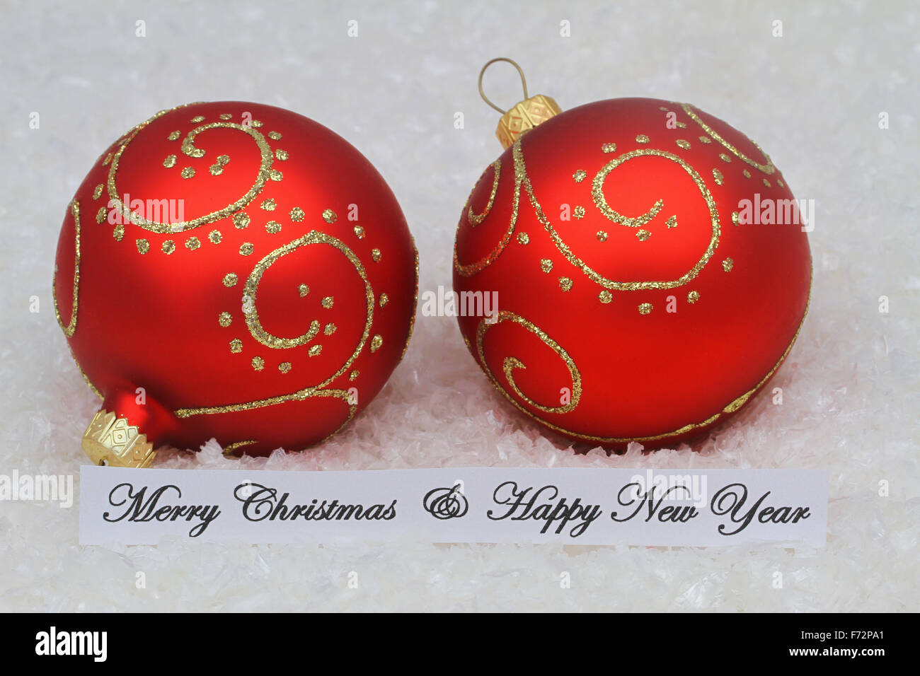 Merry Christmas and Happy New Year card with two red and golden baubles ...