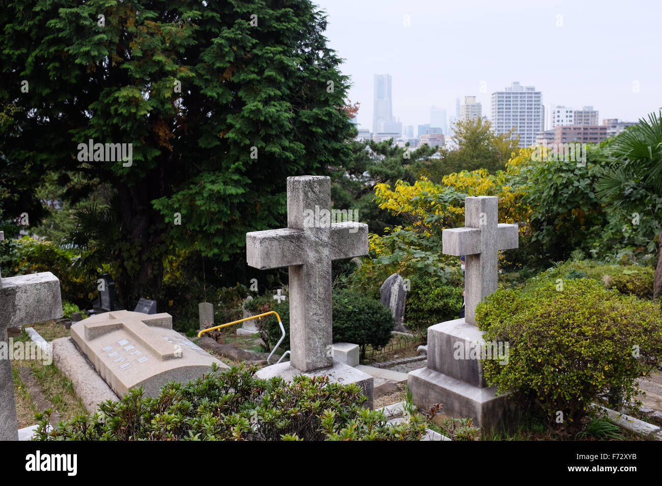 The Yokohama Foreign General Cemetery in Yokohama, Japan, with the Landmark Tower in the background. Stock Photo