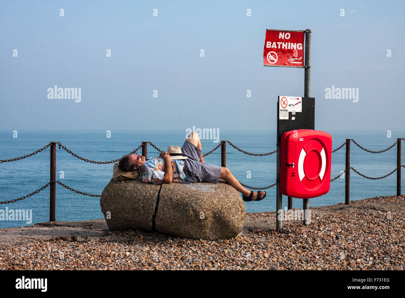 Man resting on a rock at Hastings Seafood Festival on The Stade, Hastings, East Sussex, England, UK Stock Photo
