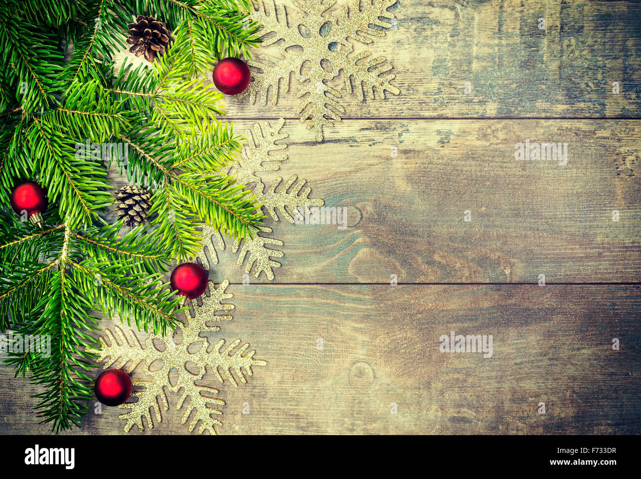 Retro toned Christmas decorations on an old wooden table, copy space, shallow depth of field. Stock Photo