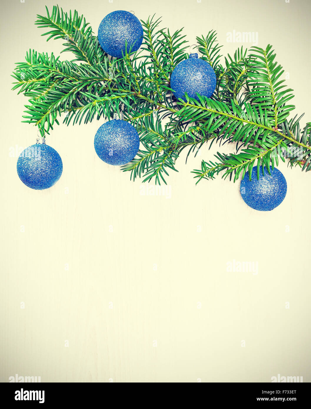 Retro toned Christmas decorations on a wooden board, copy space. Stock Photo
