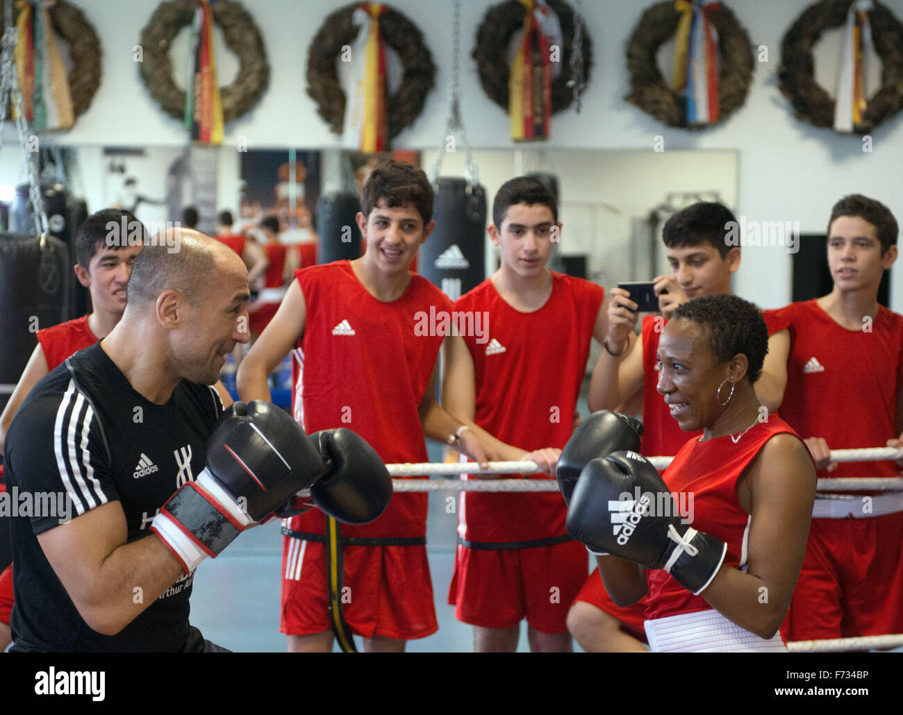 Boxing world champion Arthur Abraham (front L) spars with a young woman from Sierra Leone during a training session at the Max Schmeling Gymnasium in Berlin, Germany, 24 November 2015. The event featuring unaccompanied refugees was organised by Team Sauerland, sporting goods manufacturer Adidas, the German Confederation of Skilled Crafts and German political party CDU. Photo: SOEREN STACHE/dpa Stock Photo