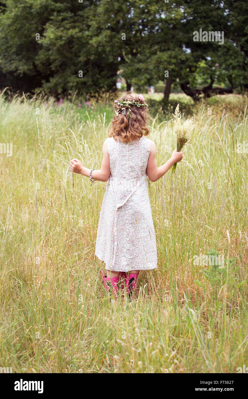 Young girl with flowers in her hair picking wild flowers in a meadow Stock Photo Alamy