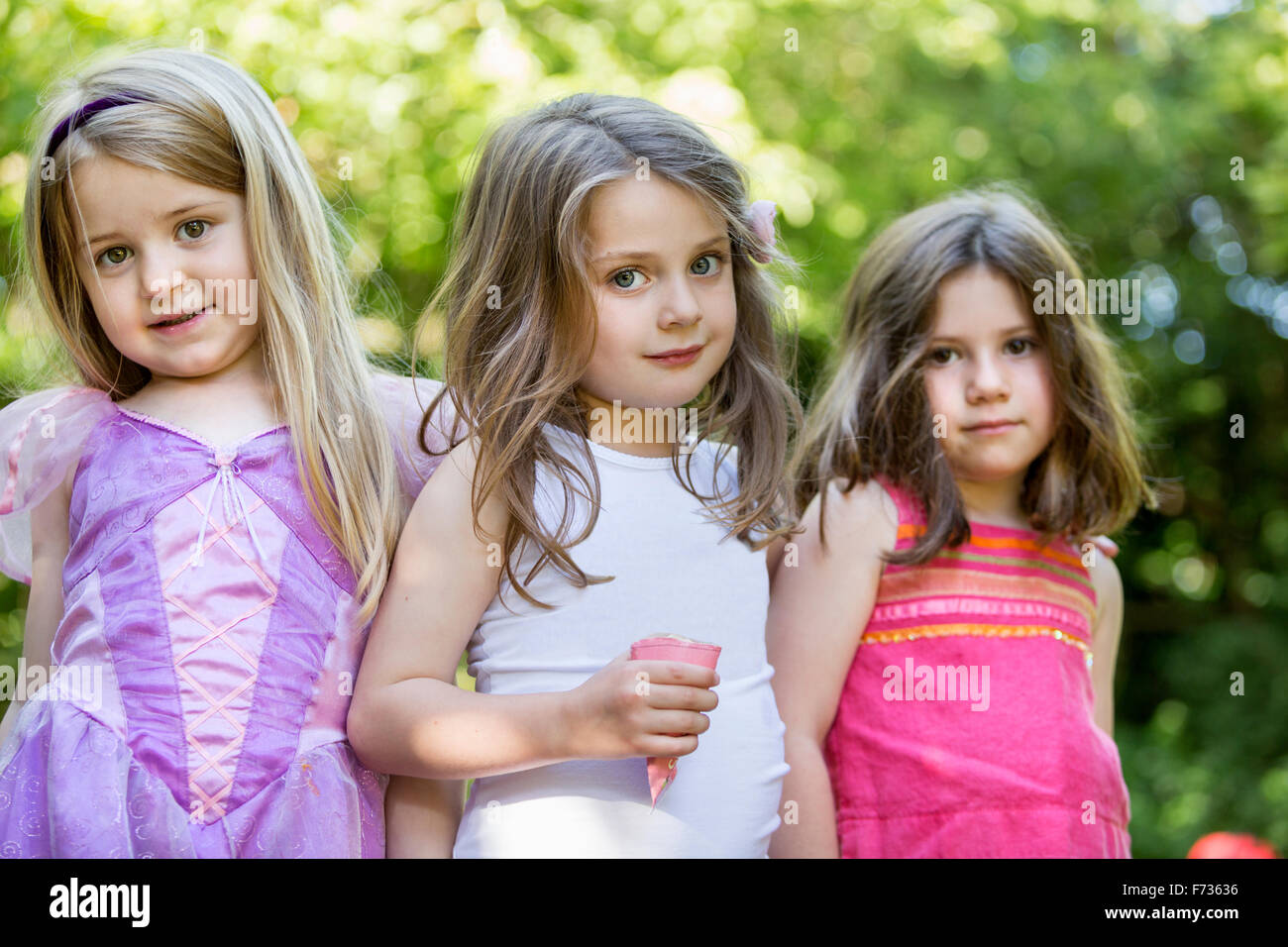 Three smiling young girls at a garden party. Stock Photo
