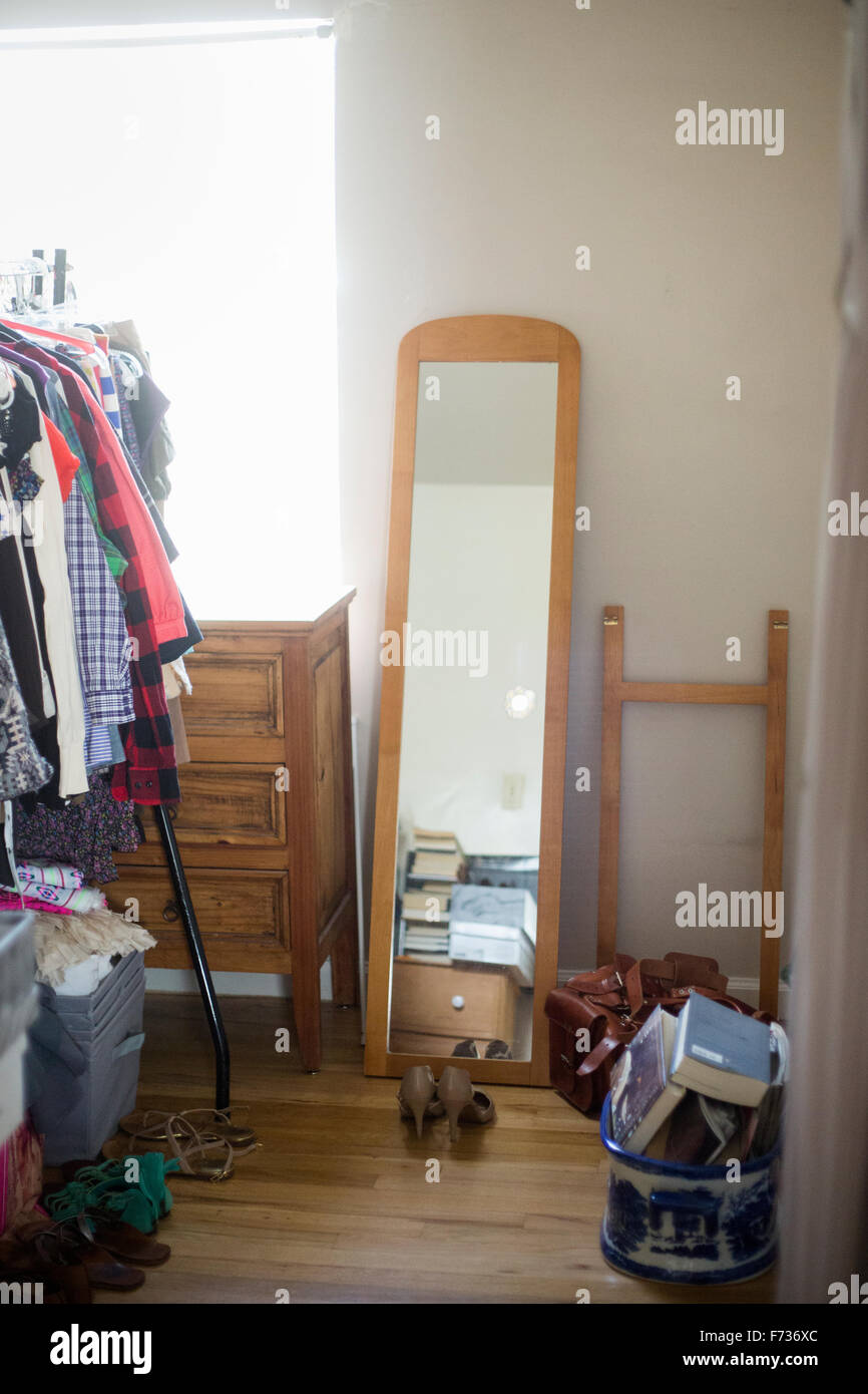 Mirror, chest of drawers, clothes rack and shoes in a bedroom. Stock Photo
