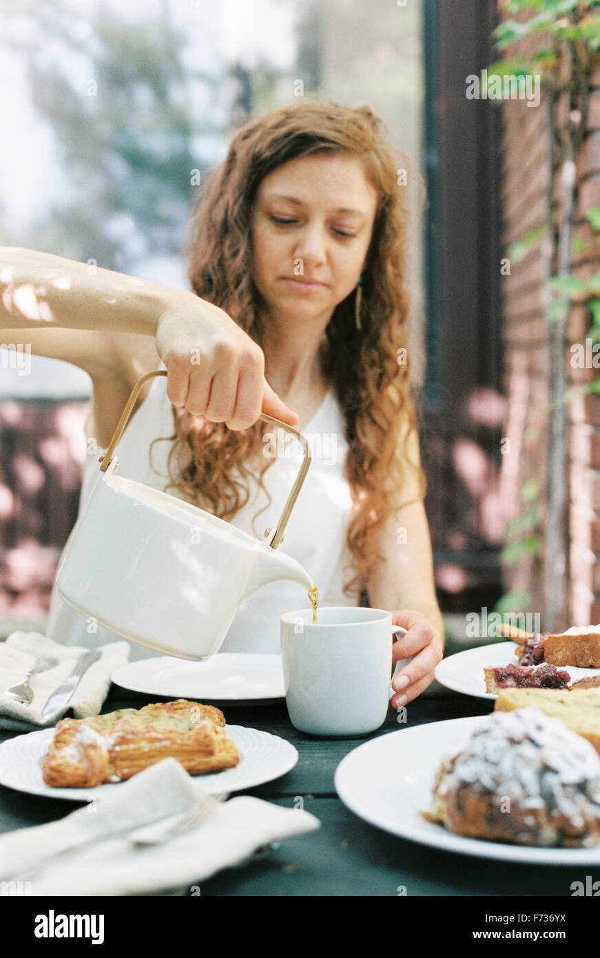 Woman pouring a cup of tea. Stock Photo
