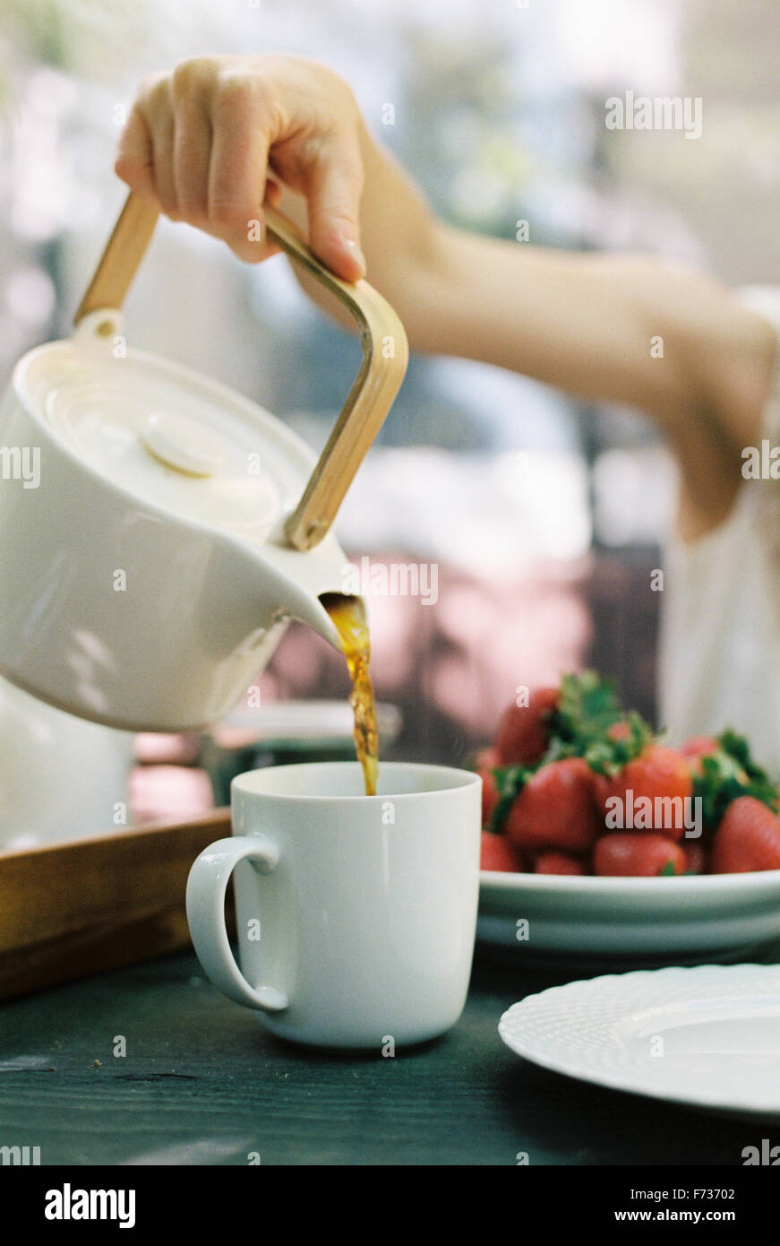 Woman pouring a cup of tea. Stock Photo