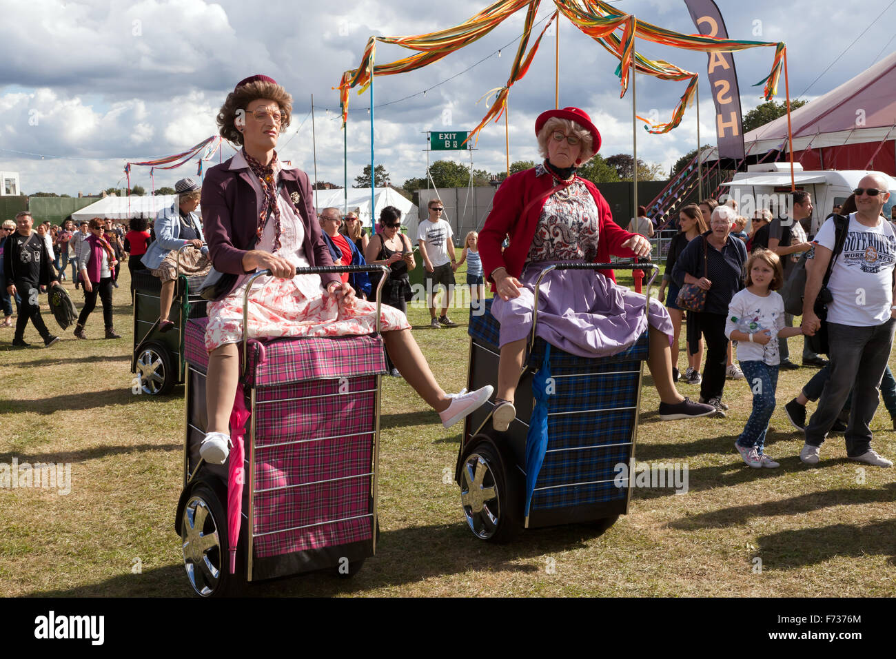 Men, dressed up as old women, riding about on giant motorized  shopping trollies, at the On Blackheath Music Festival, 2015. Stock Photo