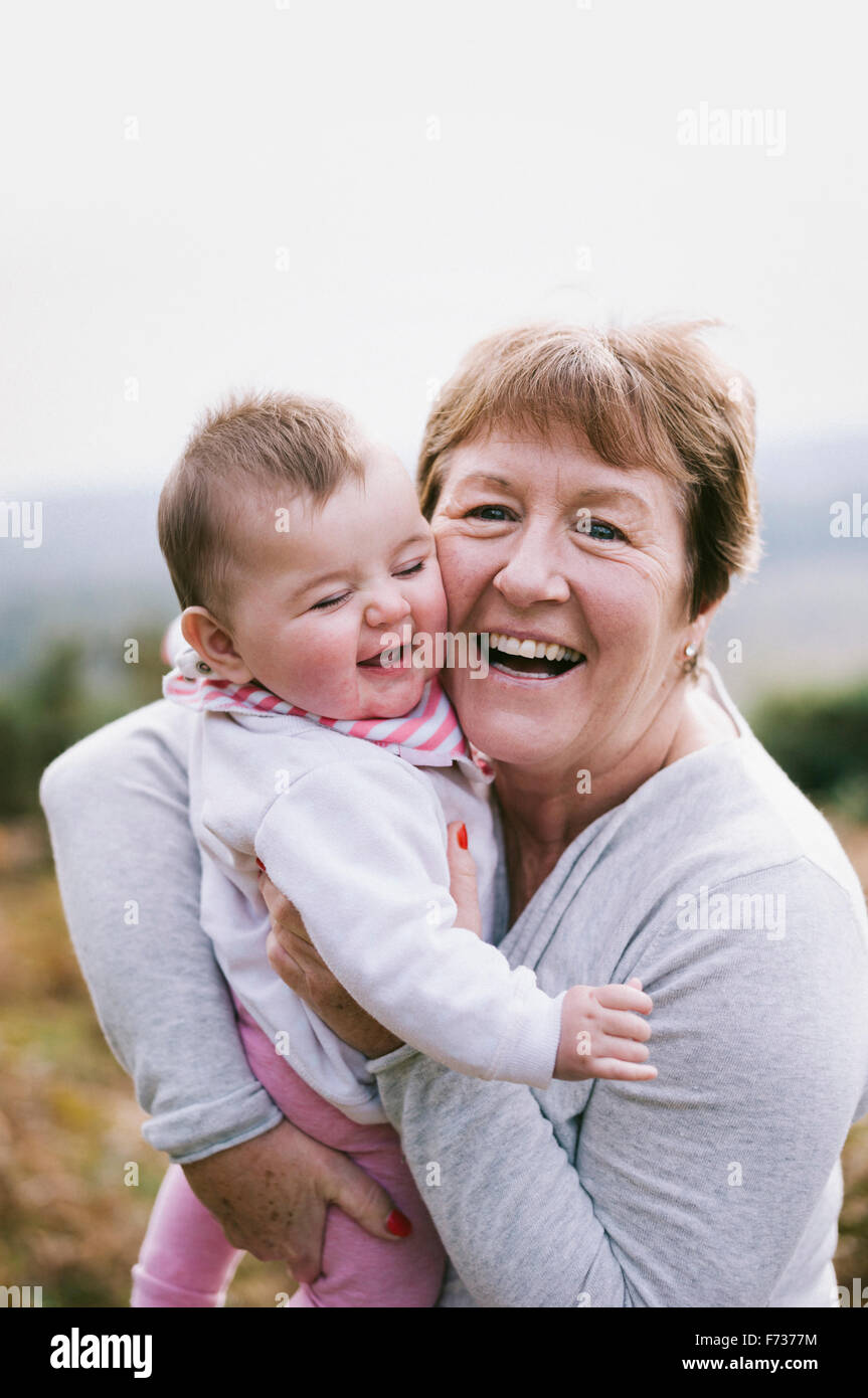 A woman holding a young baby close to her and laughing. Stock Photo