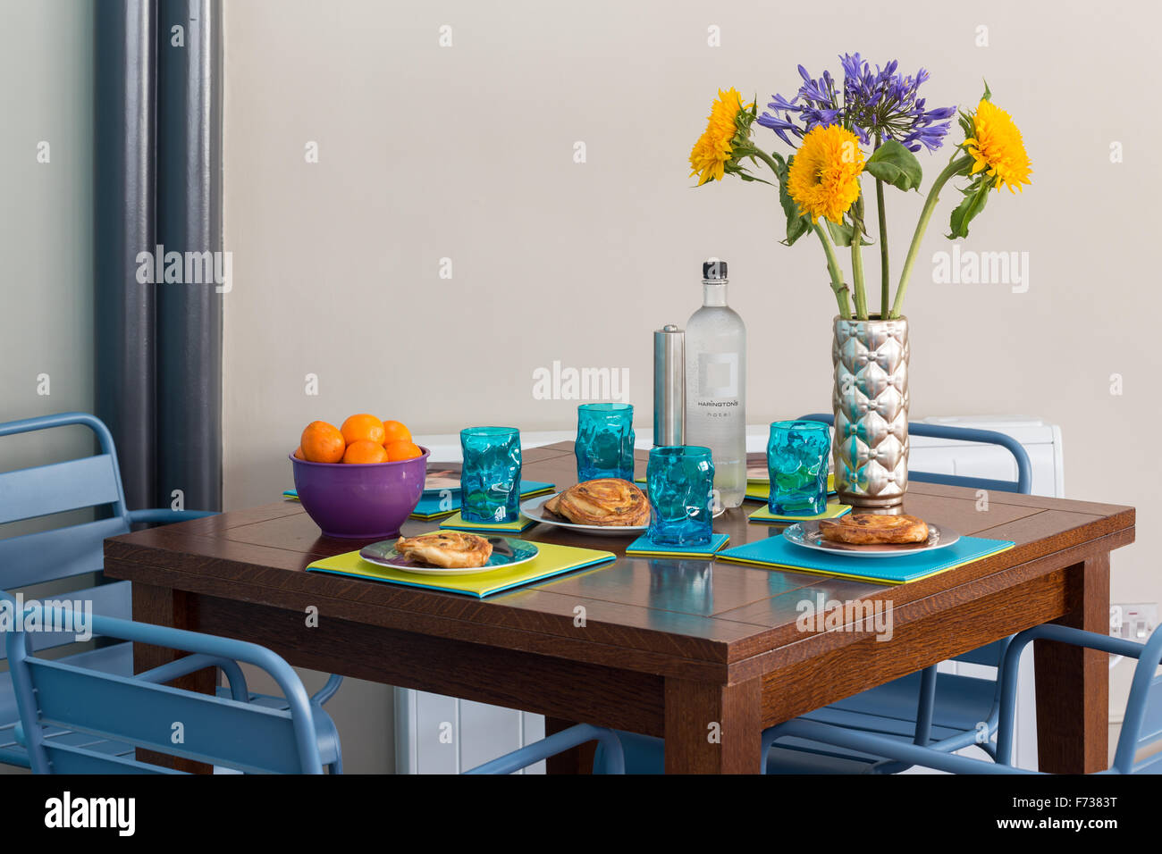 Brightly coloured contemporary dining area with table set for light continental breakfast Stock Photo