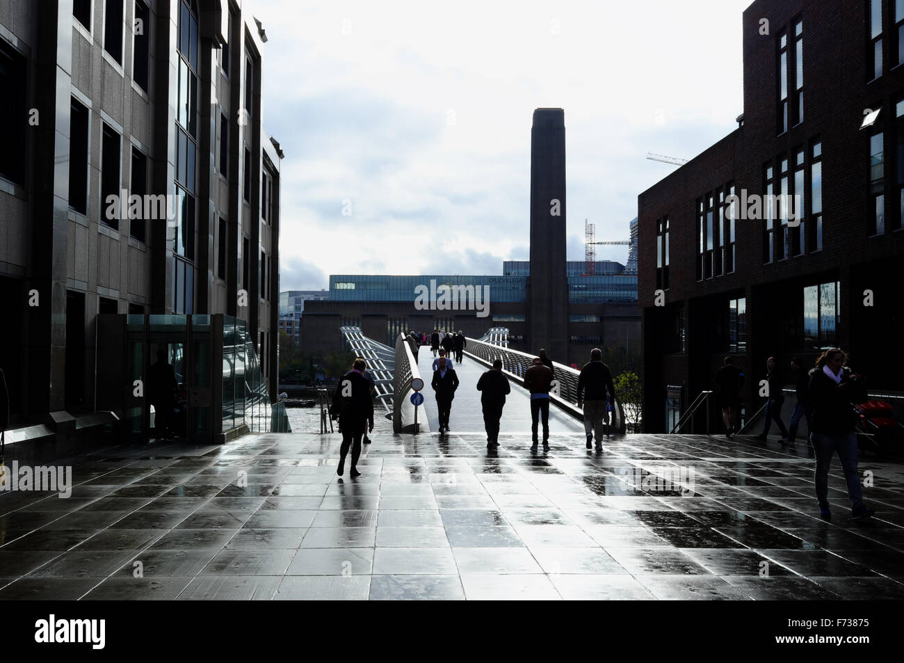 Silhouette of people approaching the millenium bridge on Bankside, London, on a rainy day Stock Photo