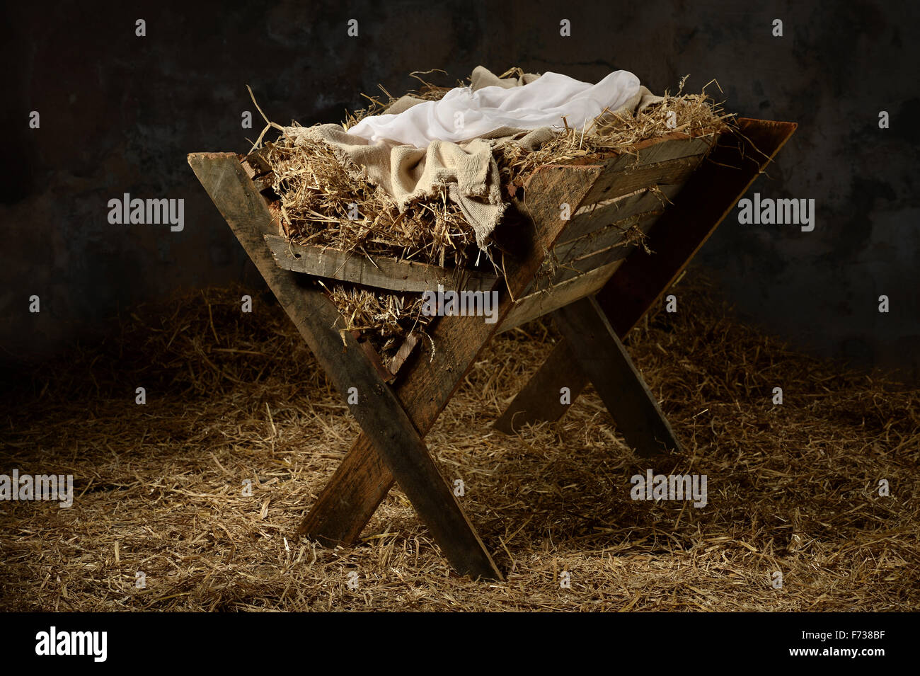 Manger with hay and swaddling clothes in old stable Stock Photo