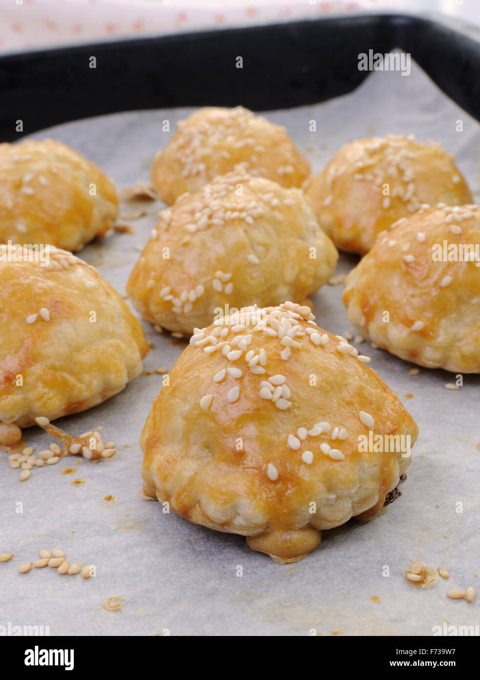Bun puff pastry with sesame seeds on a baking paper in the pan Stock Photo