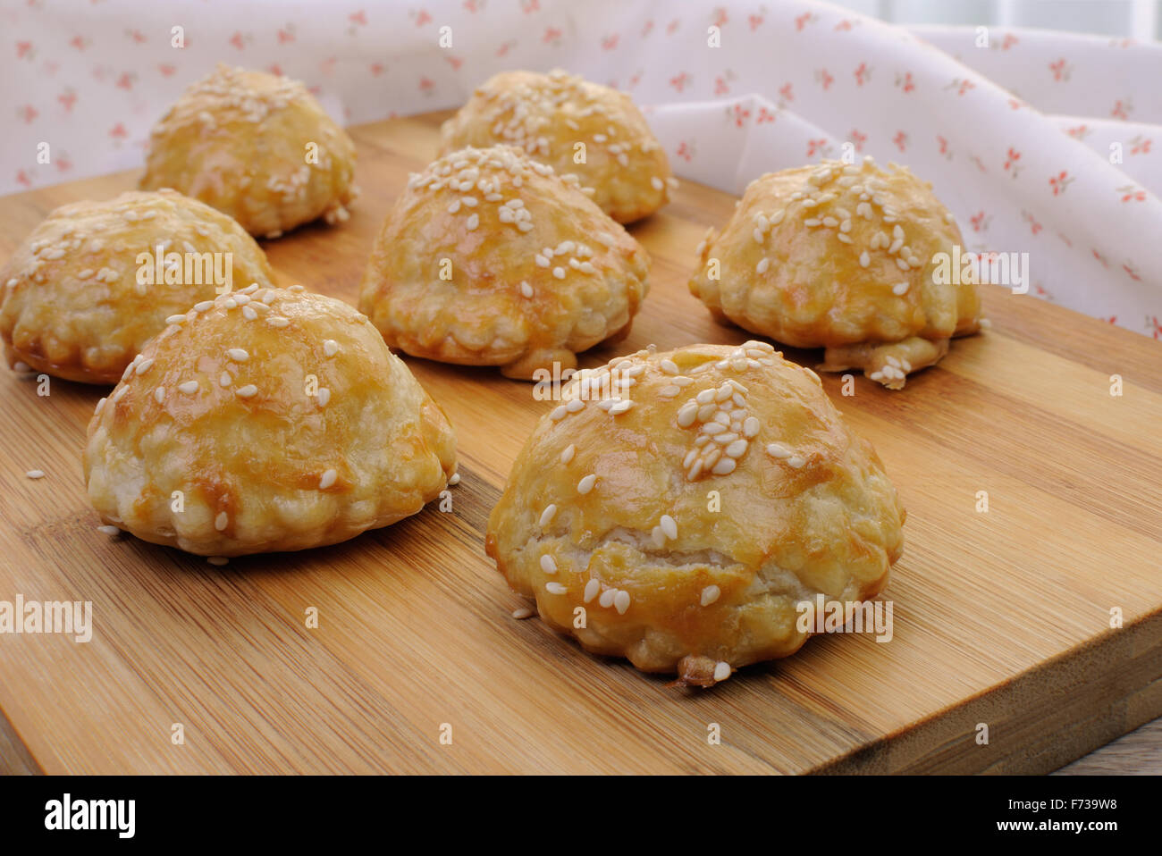 Bun puff pastry with sesame seeds on a wooden board Stock Photo