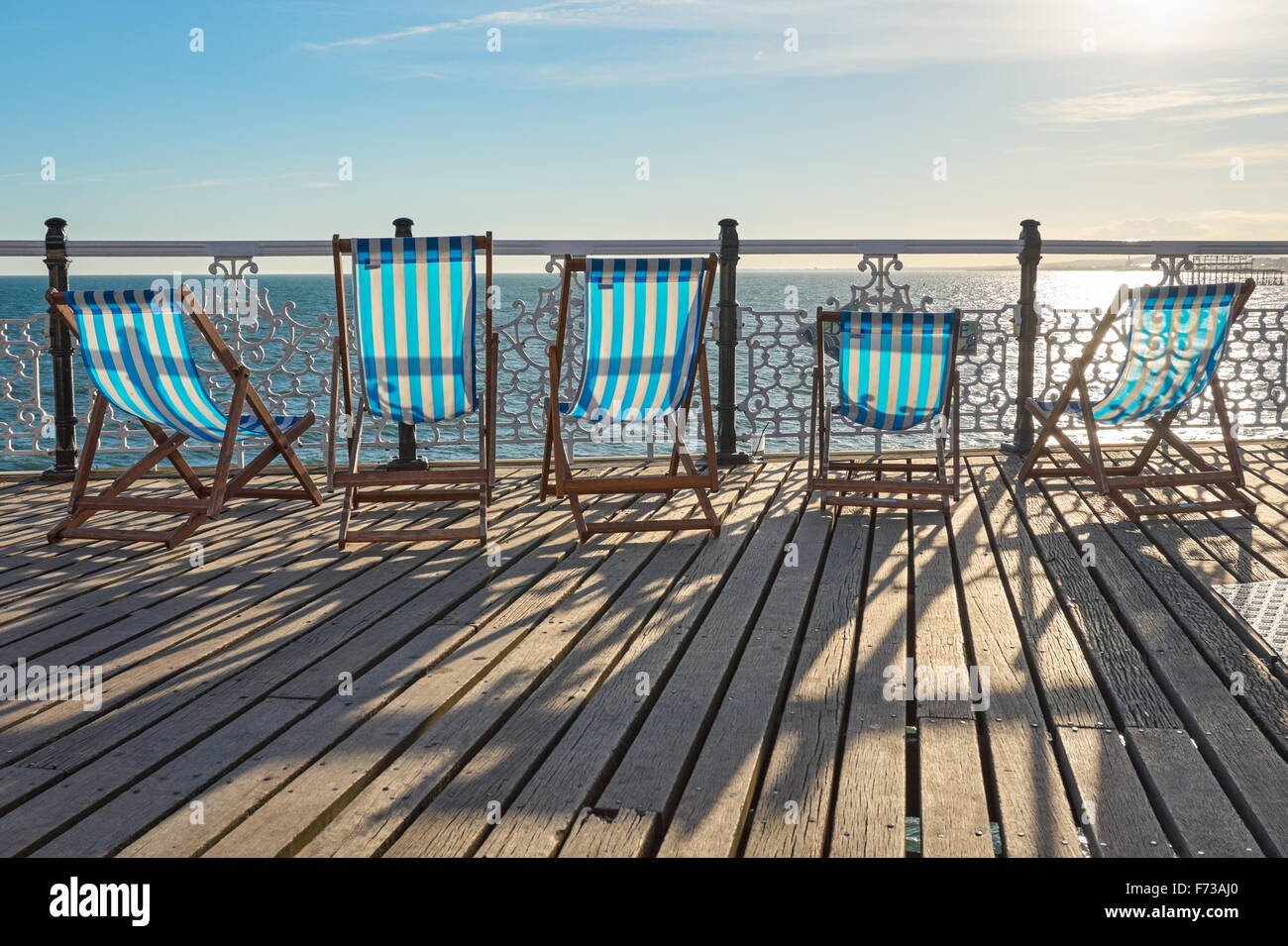 A row of wooden, empty deckchairs on Brighton Pier,  East Sussex England United Kingdom UK Stock Photo