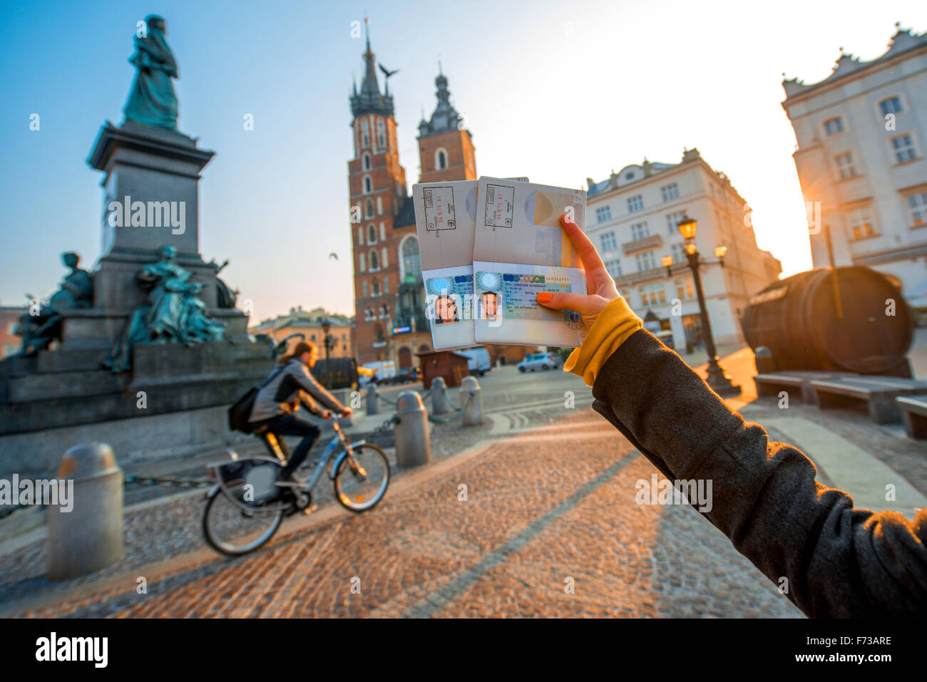 Female hands holding Ukrainian passports with Shengen visas on the Krakow city center background. Traveling to Europe from Post- Stock Photo
