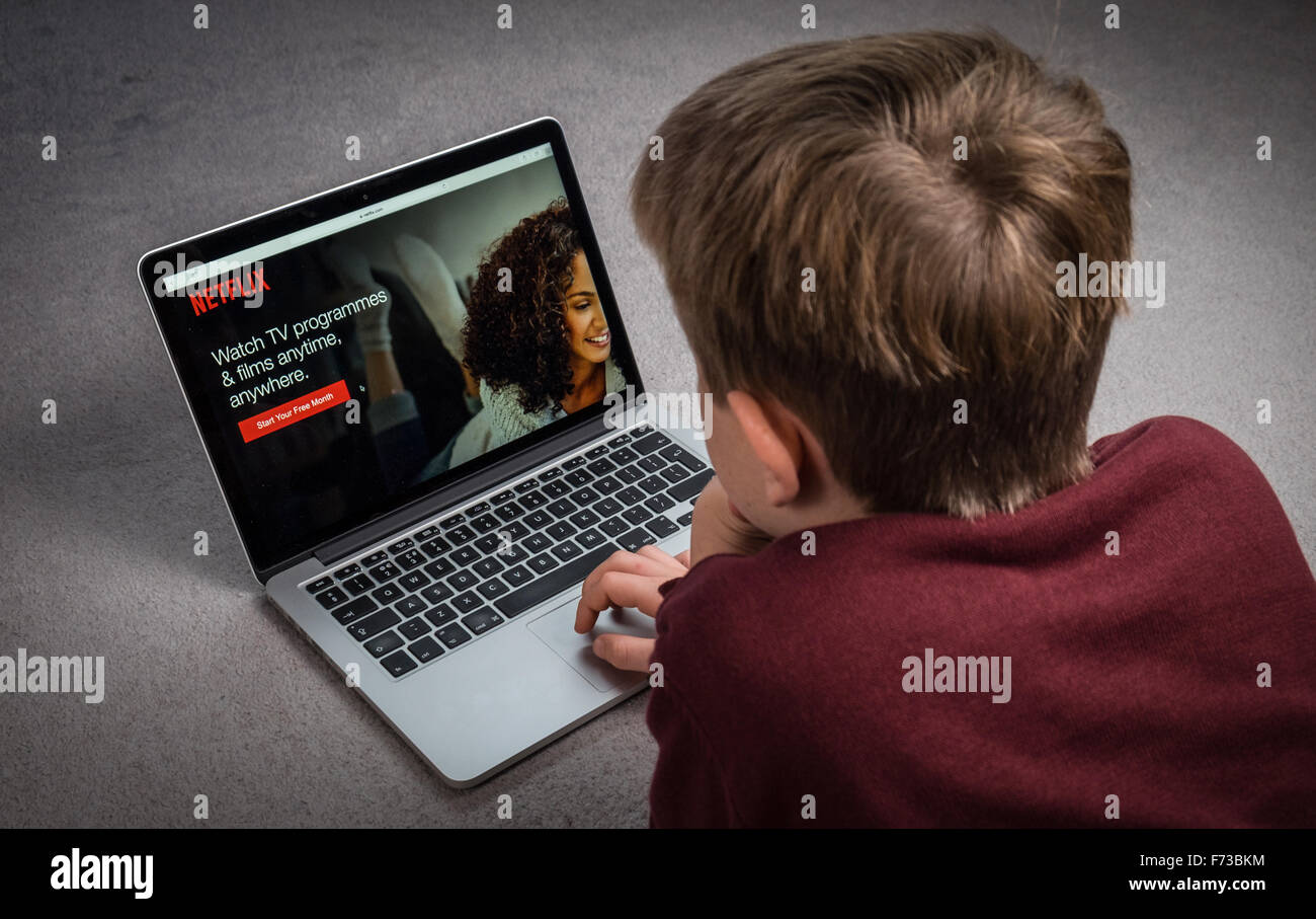 A child watching Netflix on a laptop computer Stock Photo