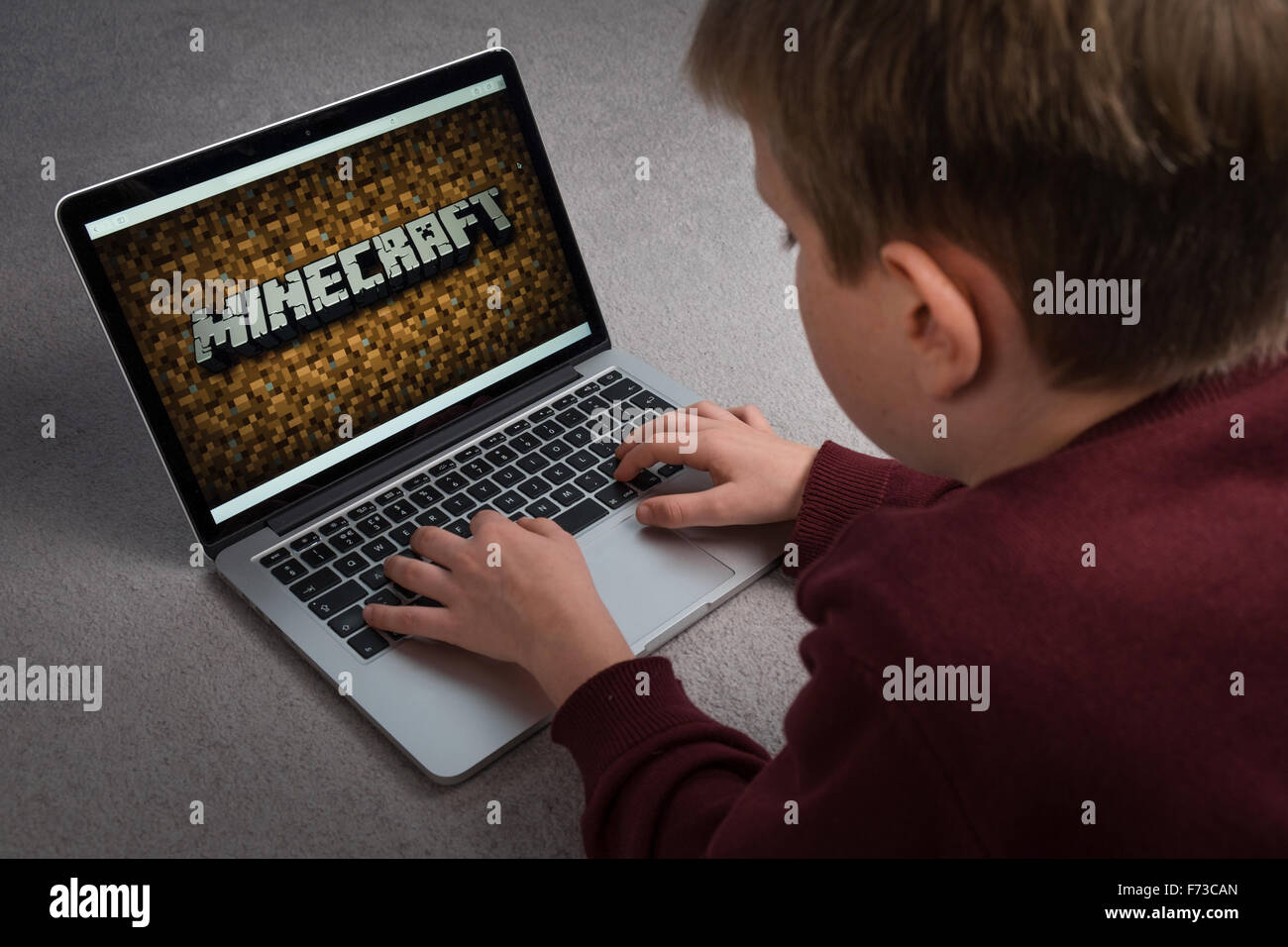 A child playing the Minecraft computer game on a laptop Stock Photo