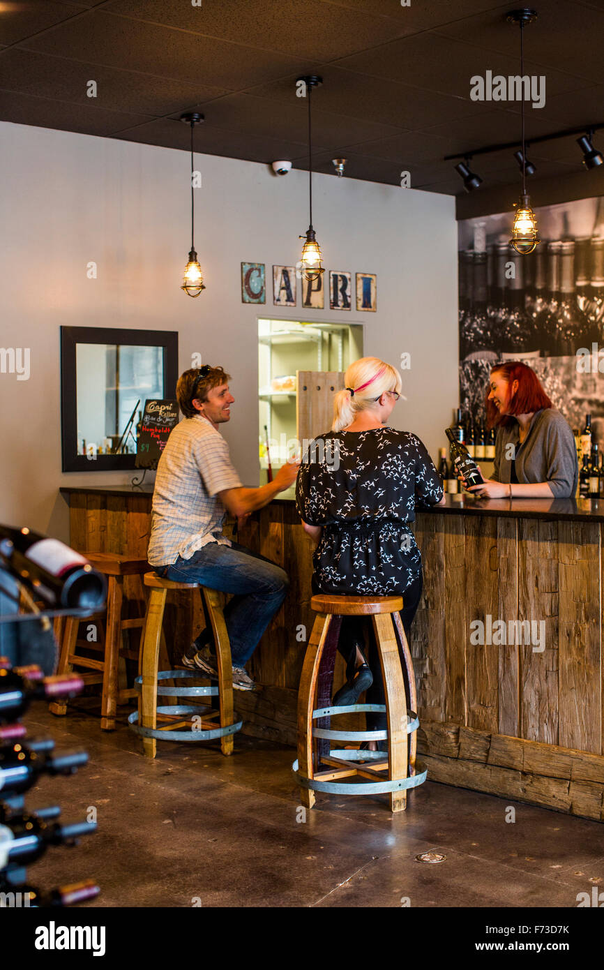 A couple sits at the bar of a wine tasting room and enjoys unique wines from all over the Northwest. Stock Photo