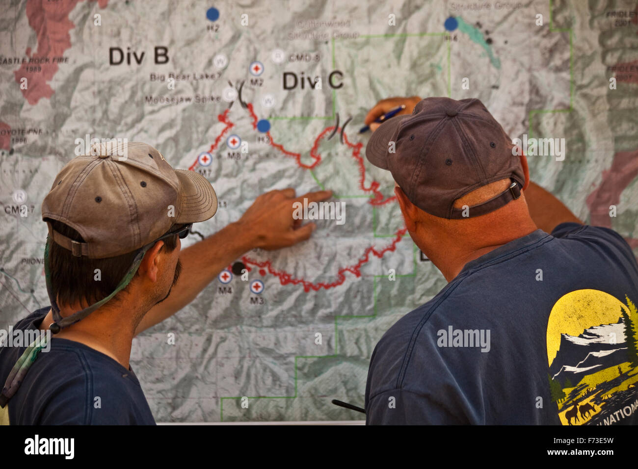 Two wild land firefighters look at a map to decide the day's plan of attack. Stock Photo