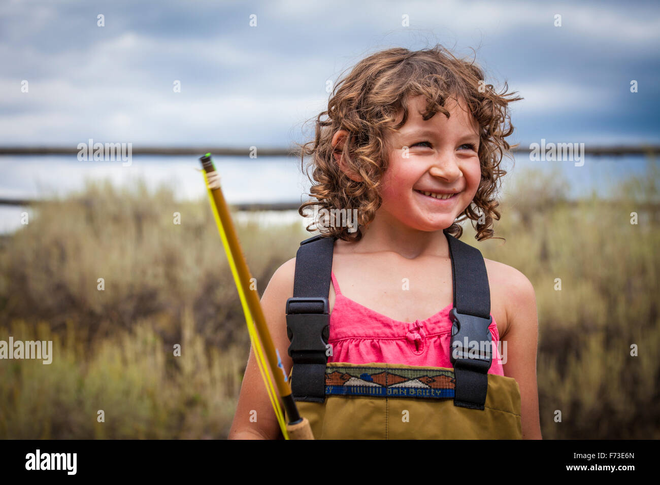 A young girl smiles while getting ready to fly fish in Idaho. Stock Photo