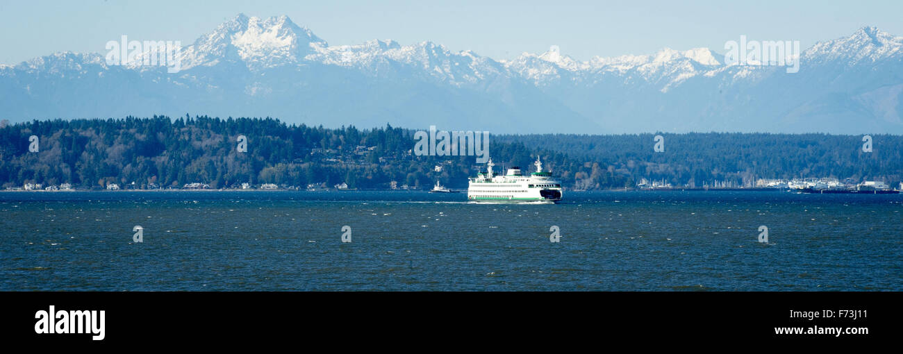 Seattle, Washington, USA. 21st Nov, 2015. The Washington State Ferry system, operating under the Department of Transportation, operates about two dozen specially made ferries along 10 different routes to 20 different terminals located within Puget Sand and the San Juan Islands. As part of the Washington State Highway system, the distinctive green and white painted hull is easily recognized visually. --- In the photo, the MV Tacoma approaches the Seattle terminal inbound from Bainbridge Island with the Olympic Mountain Range visible in the distance. © David Bro/ZUMA Wire/Alamy Live News Stock Photo