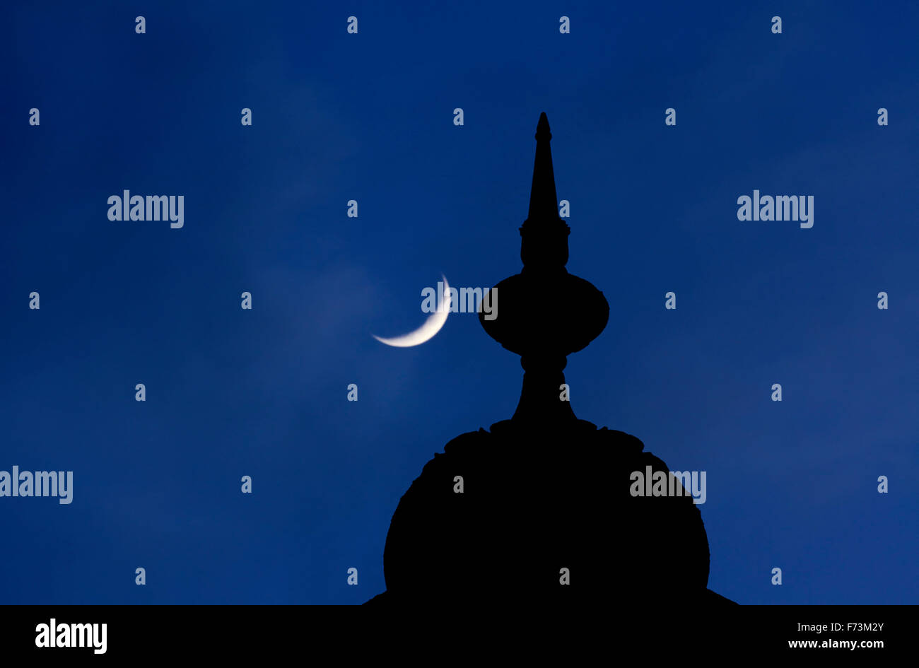 A small dome and finial on top of a minaret on Brighton Pavilion. Crescent moon behind. Stock Photo