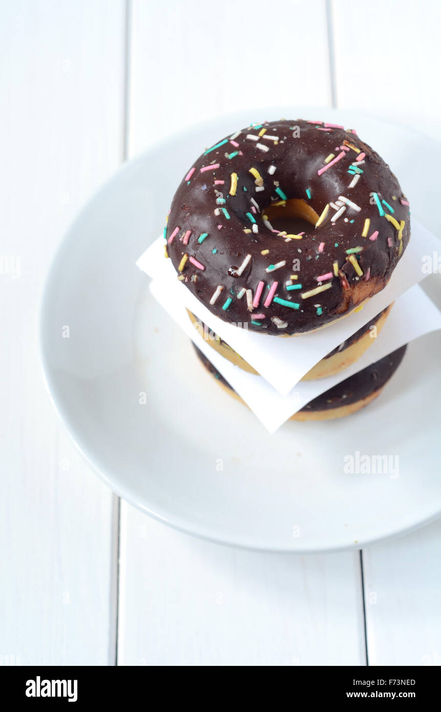 Group of glazed donuts on white wooden background Stock Photo - Alamy