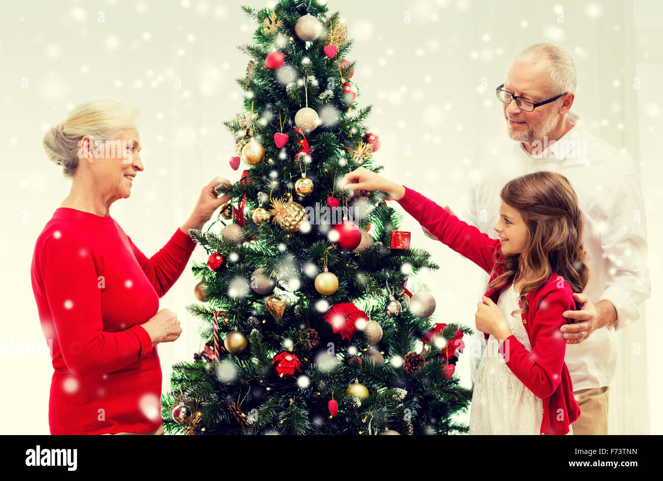 smiling family decorating christmas tree at home Stock Photo