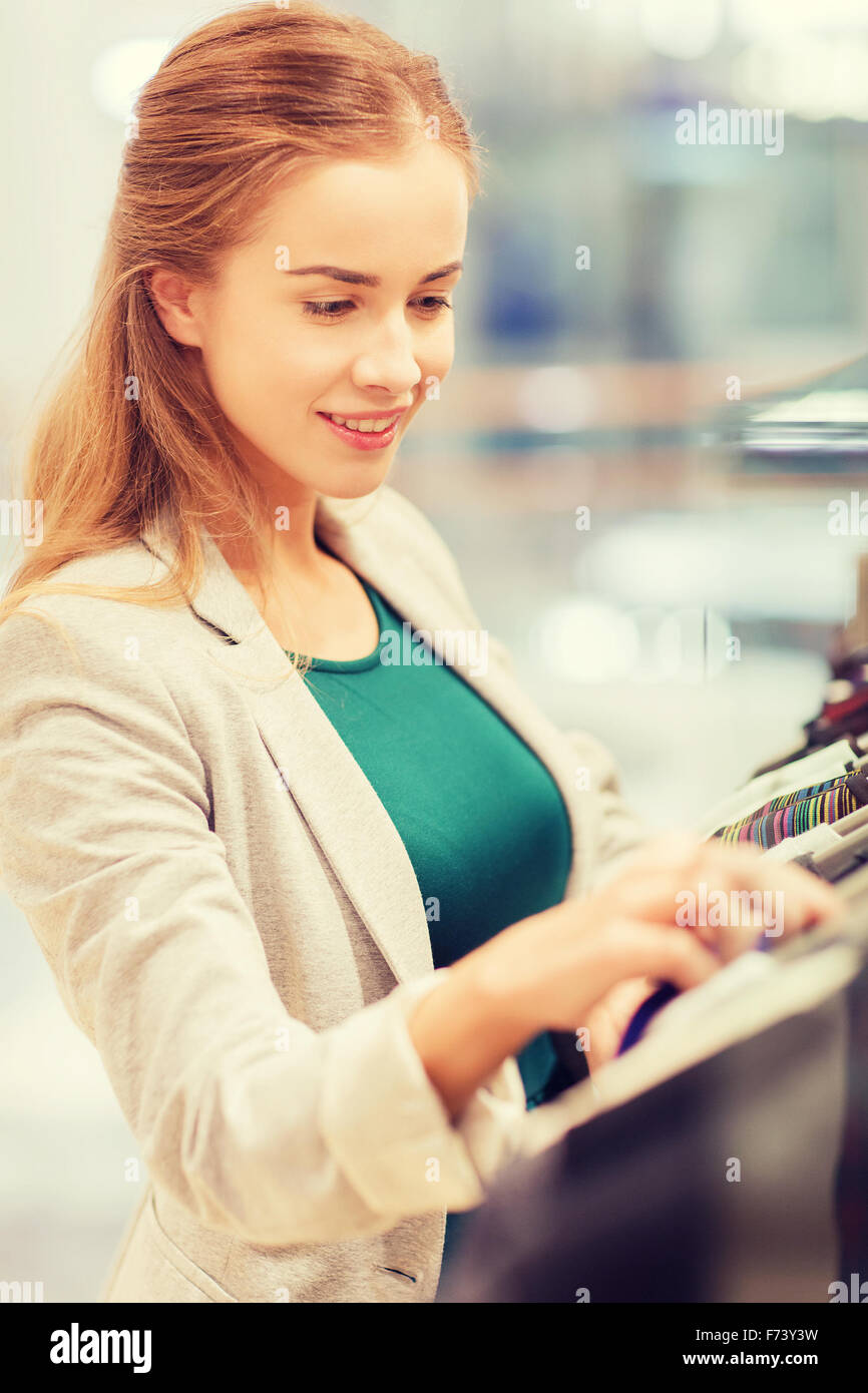 happy young woman choosing clothes in mall Stock Photo
