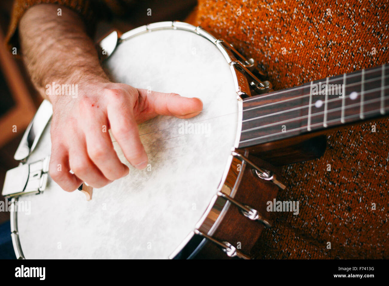 Close up of a Male Banjo player relaxing on the porch, practicing and picking away Stock Photo